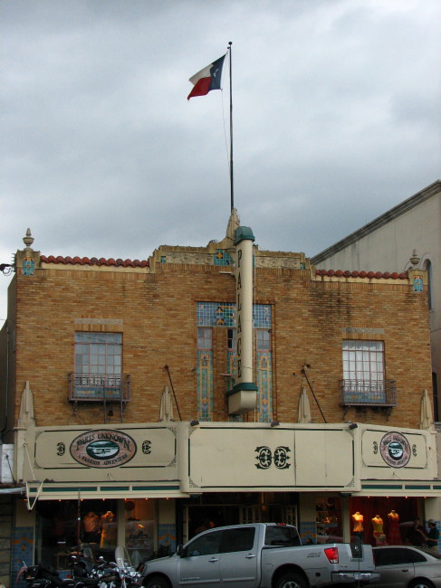Old building in Fredericksburg with the Texas flag flying above it
